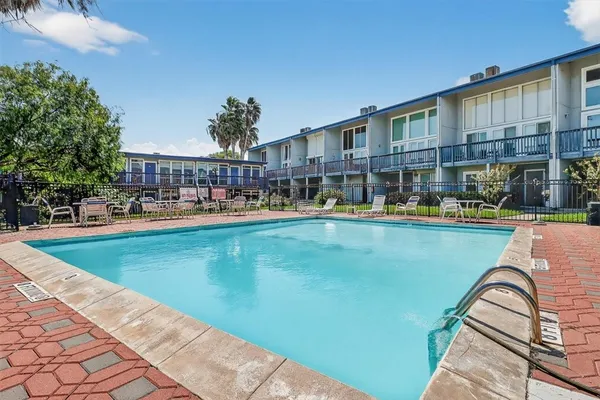 a view of swimming pool with outdoor seating and a garden