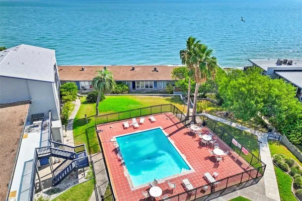an aerial view of a house with outdoor space pool seating area and covered with green space