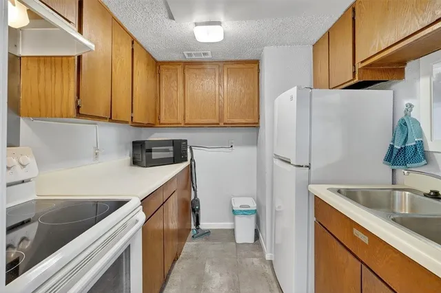 a kitchen with a sink a refrigerator a stove a washer and dryer