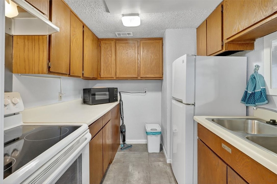 3402 Ocean Drive Corpus Christi, TX 78411 - Photo 9 of 39 a kitchen with a sink a refrigerator a stove a washer and dryer