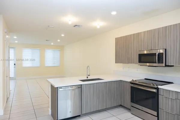 a kitchen with a sink and a stove top oven with wooden floor