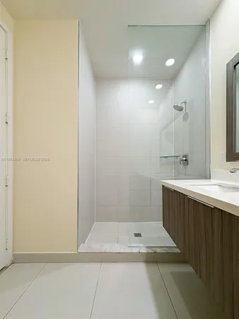 a bathroom with a sink a shower and a mirror