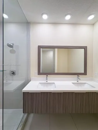 a bathroom with a double vanity sink a mirror and a bathtub