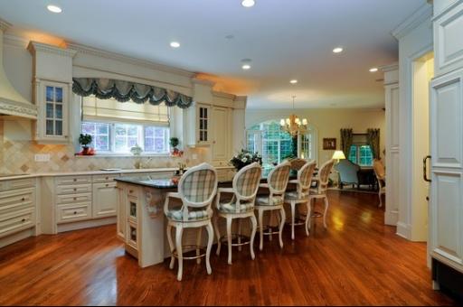 13 Riderwood Road North Barrington, IL 60010 - Photo 5 of 16 a kitchen with stainless steel appliances dining table chairs and wooden floor