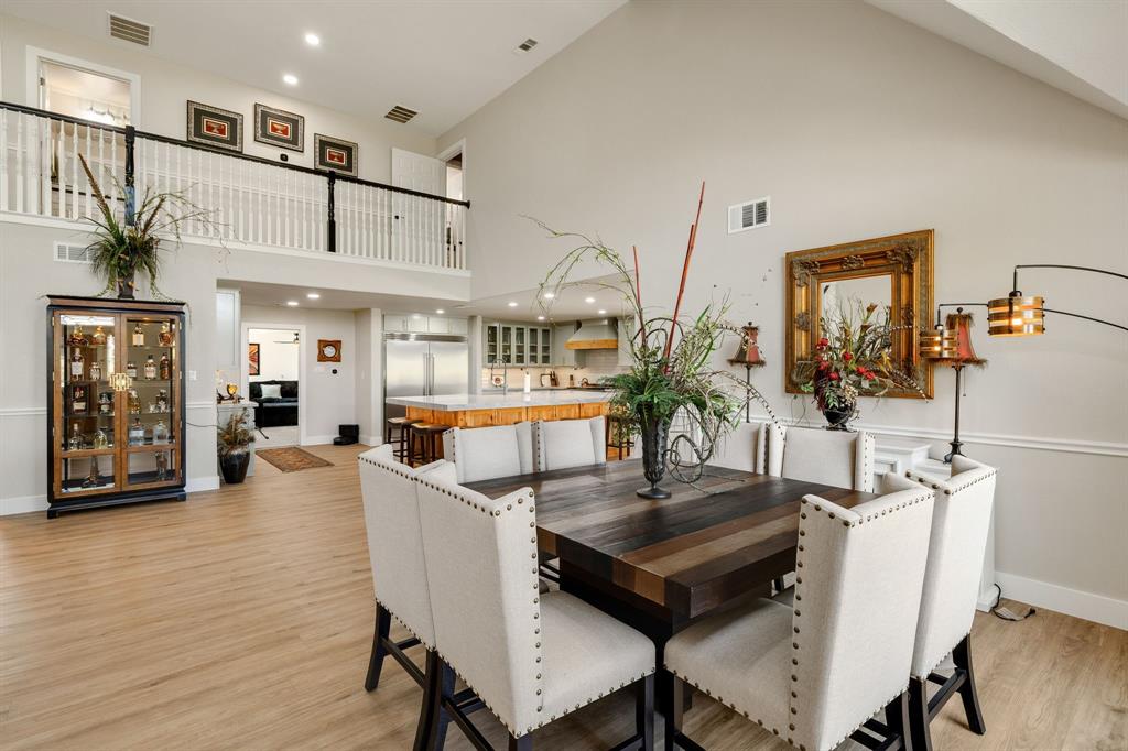 12240 Wellington Road Ponder, TX 76259 - Photo 8 of 40 Spacious living area featuring high vaulted ceilings, light wood-finish flooring, and a second-story open balcony with white balusters