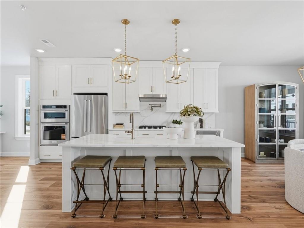 Gorgeous Gourmet Kitchen featuring 30'' gas cooktop, kitchen aid appliances including full size refrigerator and beverage fridge, quartz countertops and backsplash, and more!