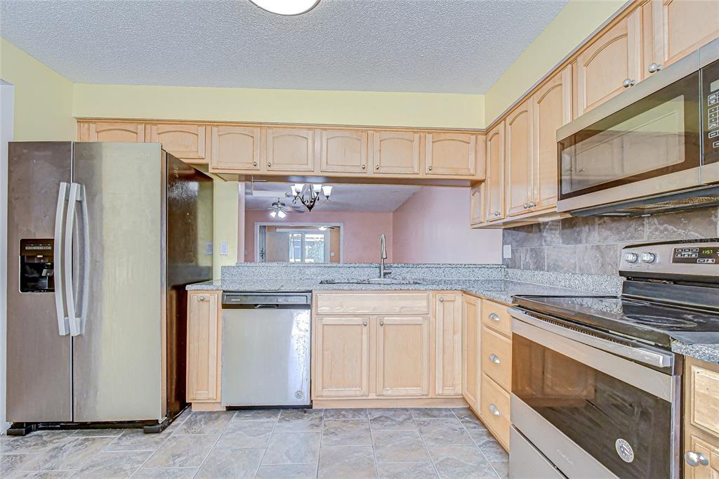 602 Fieldcrest Drive Brandon, FL 33511 - Photo 6 of 23 a kitchen with stainless steel appliances granite countertop a refrigerator stove and sink