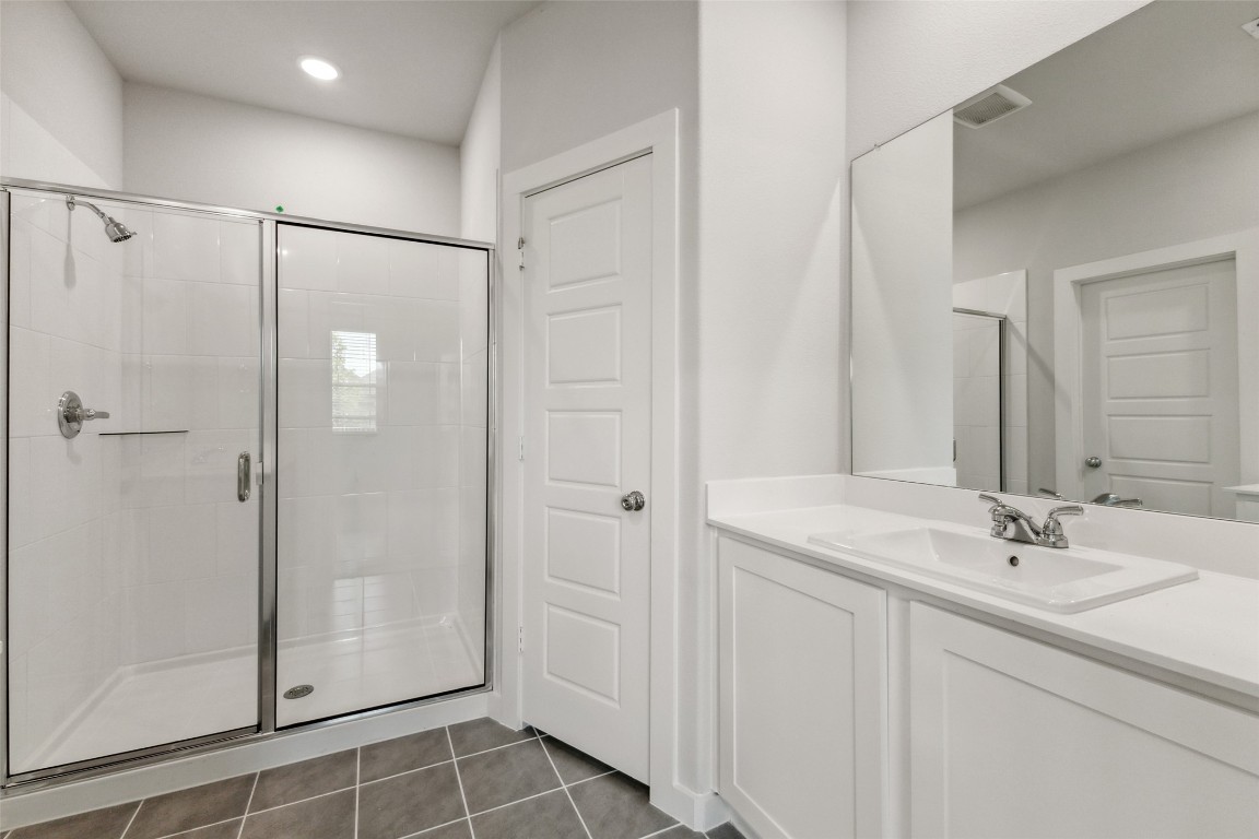 153 Tolo Drive Elgin, TX 78621 - Photo 12 of 25 a bathroom with a shower sink and mirror