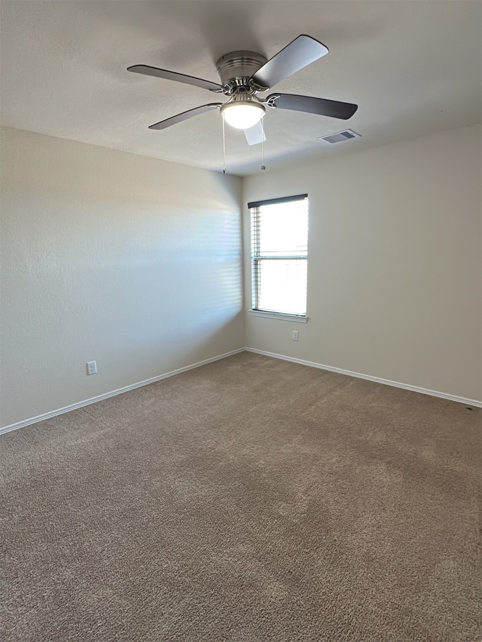 9931 Swindale Ridge Lane Houston, TX 77044 - Photo 19 of 29 an empty room with a window and a fan