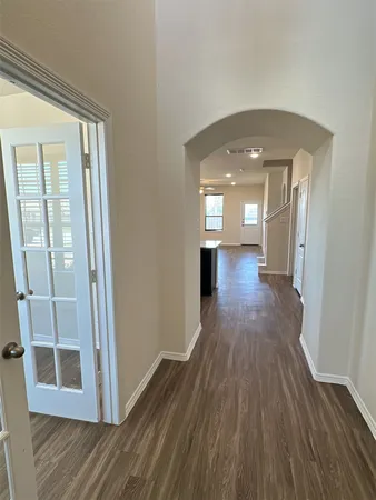 a view of a hallway with wooden floor and staircase