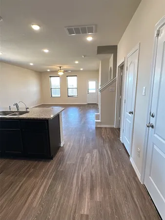 a kitchen with a sink and wooden floor