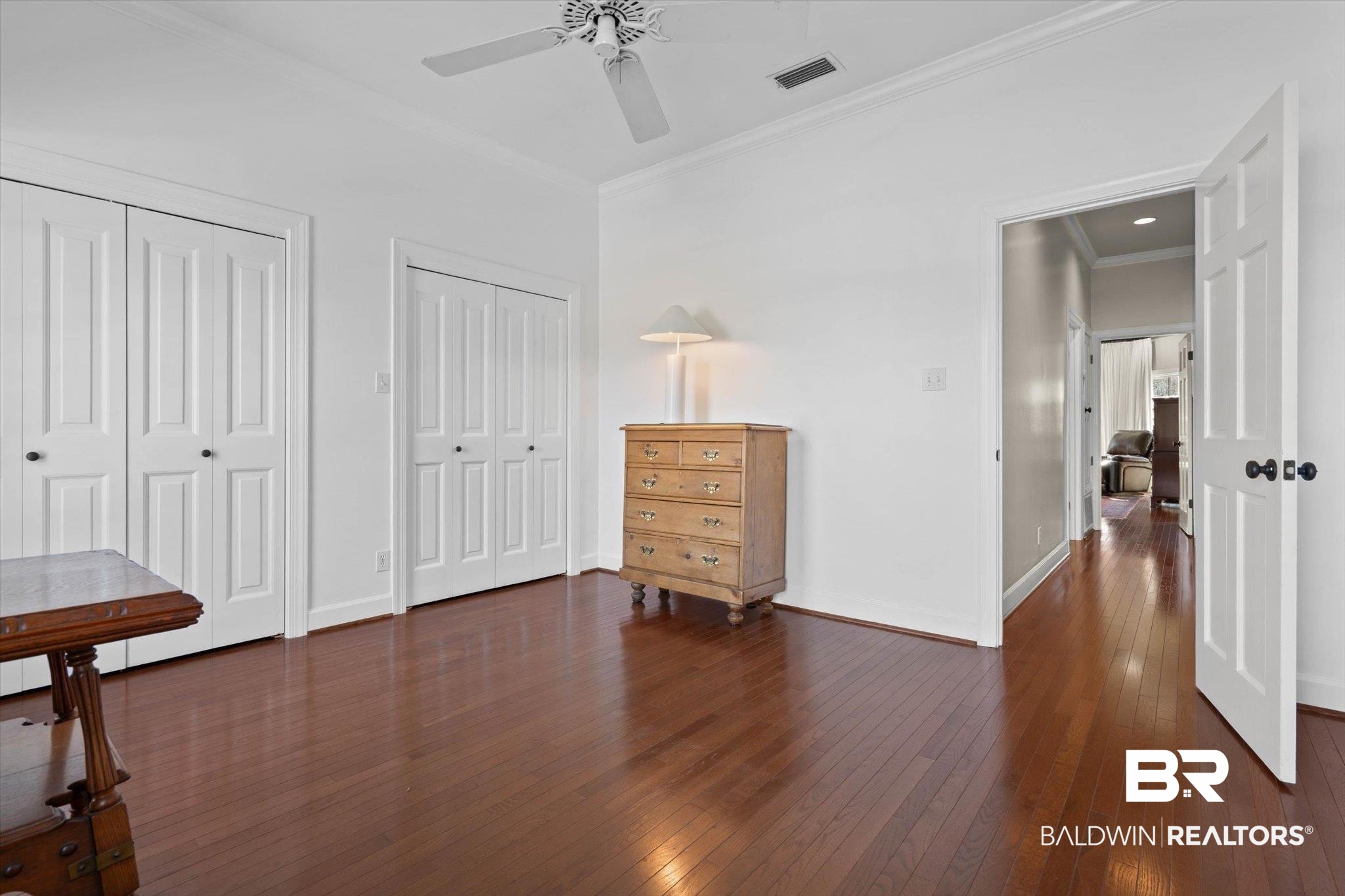 3615 Stein Street Mobile, AL 36608 - Photo 27 of 44 Bedroom with two closets, dark wood-style floors, crown molding, and a ceiling fan