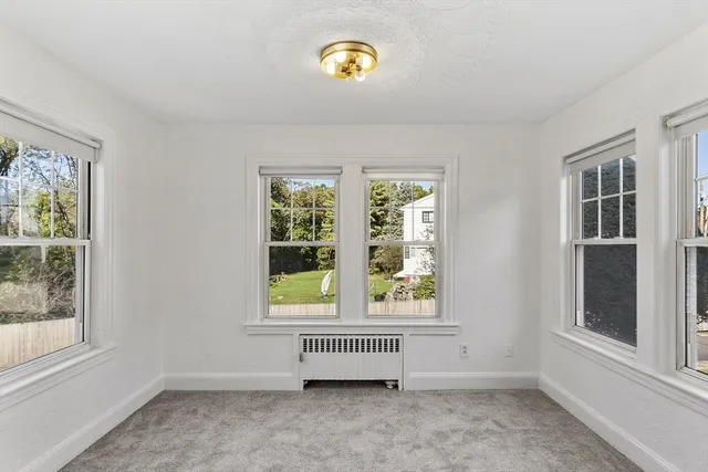 an empty room with windows and view of bedroom