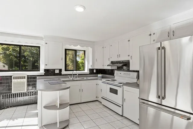 a kitchen with kitchen island a counter top space appliances and cabinets