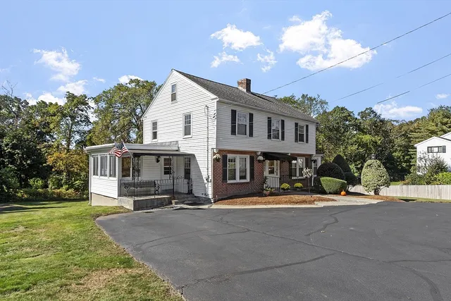 a view of a house with a big yard and large trees