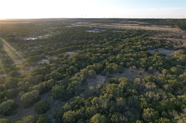 an aerial view of residential houses with outdoor space and trees
