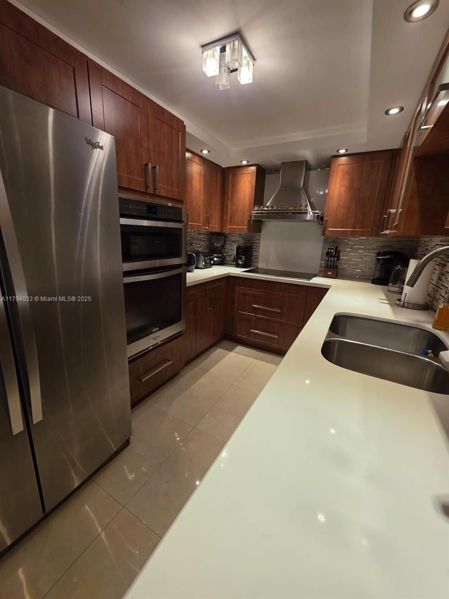 9225 Collins Avenue, Unit 1409 Surfside, FL 33154 - Photo 12 of 41 a kitchen with stainless steel appliances a refrigerator and a stove