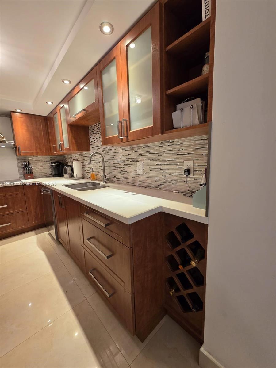 9225 Collins Avenue, Unit 1409 Surfside, FL 33154 - Photo 14 of 41 a kitchen with a sink and cabinets