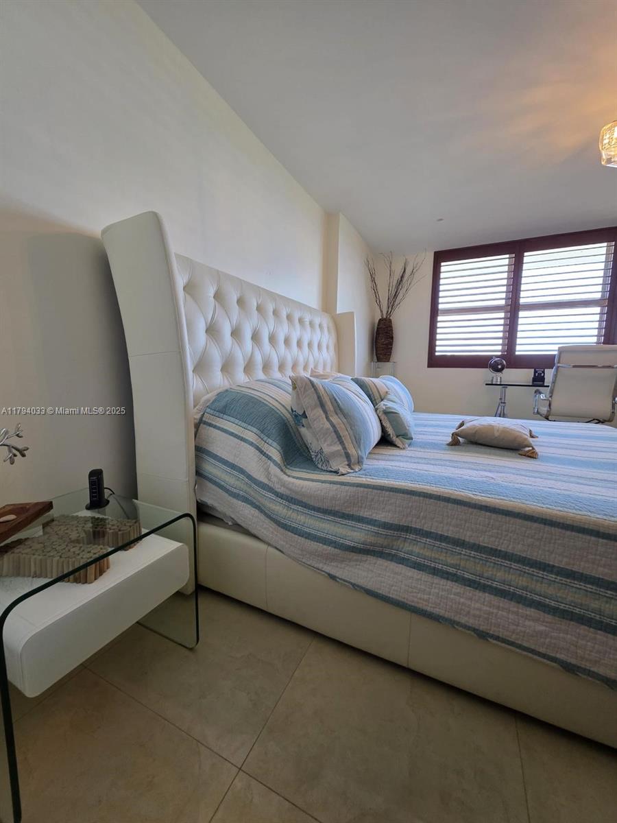 9225 Collins Avenue, Unit 1409 Surfside, FL 33154 - Photo 17 of 41 a bedroom with a bed and window