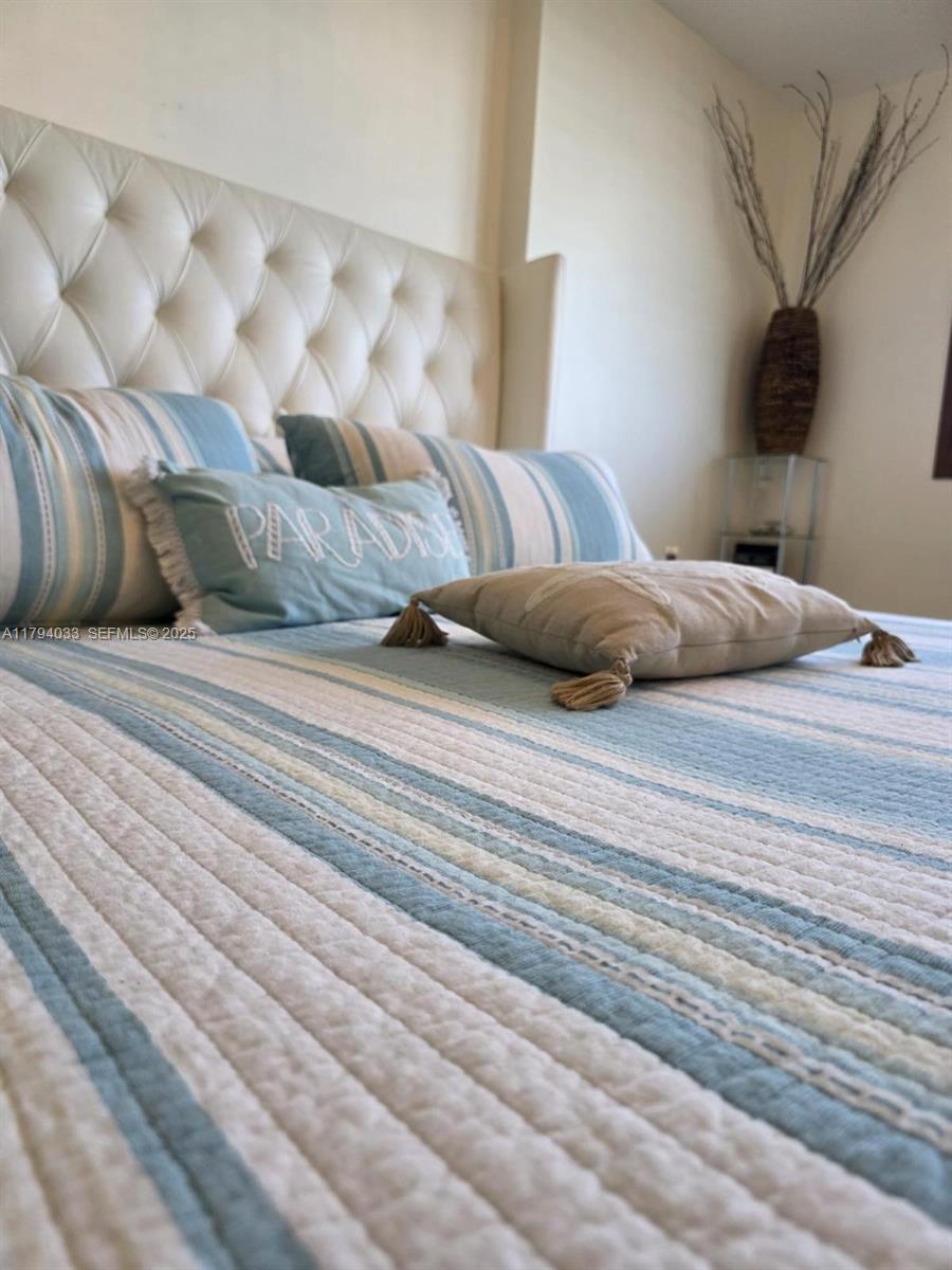 9225 Collins Avenue, Unit 1409 Surfside, FL 33154 - Photo 21 of 41 a bedroom with a bed and a night stand