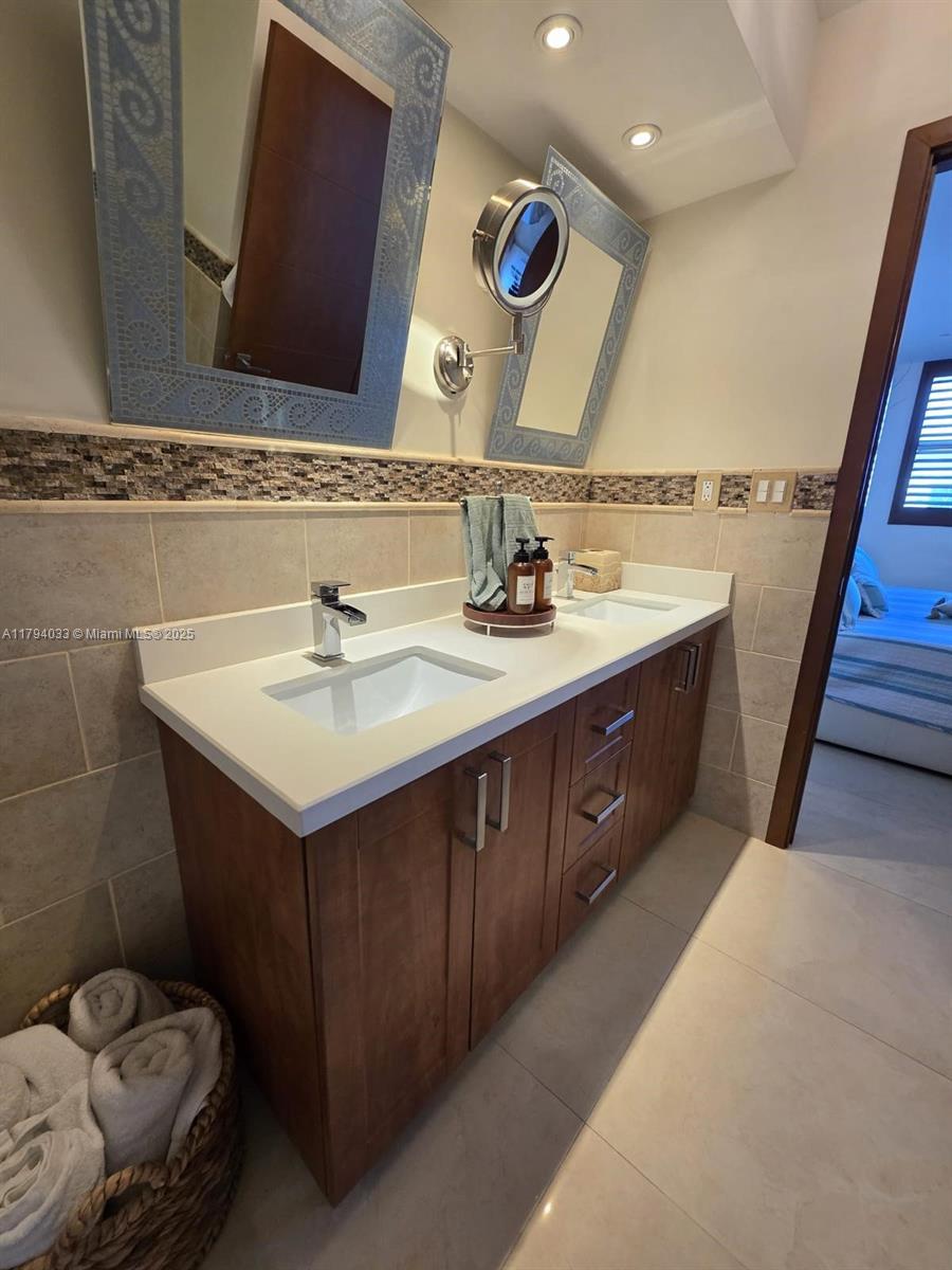 9225 Collins Avenue, Unit 1409 Surfside, FL 33154 - Photo 25 of 41 a bathroom with a sink and a mirror