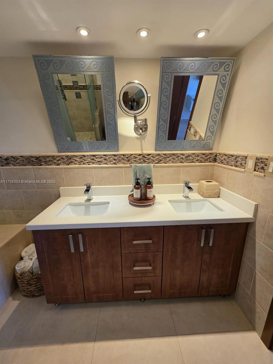 9225 Collins Avenue, Unit 1409 Surfside, FL 33154 - Photo 26 of 41 a bathroom with a sink and a mirror