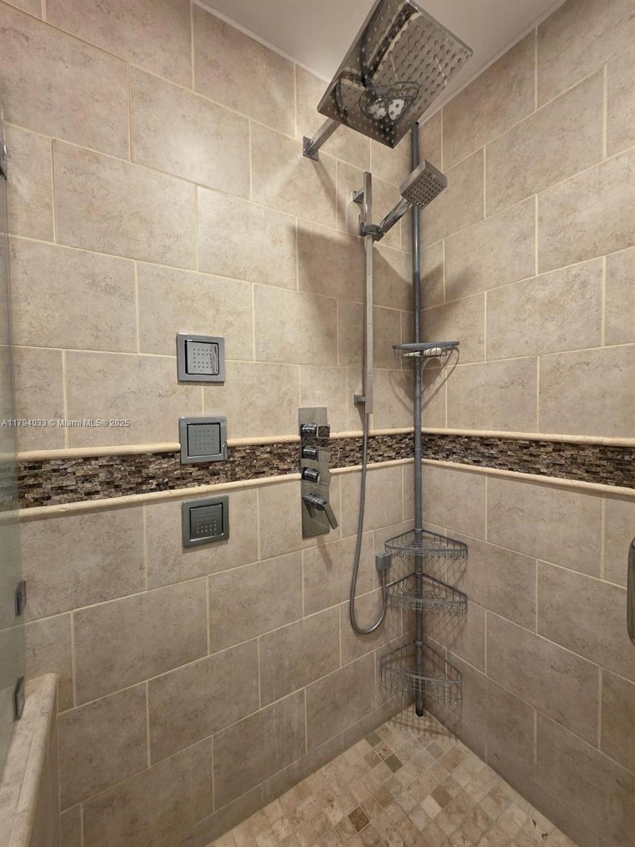 9225 Collins Avenue, Unit 1409 Surfside, FL 33154 - Photo 27 of 41 a bathroom with a shower and mirror