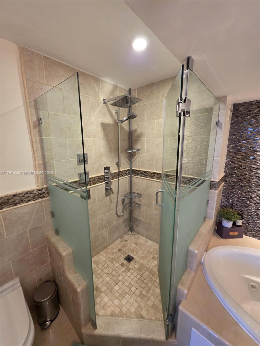 9225 Collins Avenue, Unit 1409 Surfside, FL 33154 - Photo 28 of 41 a bathroom with a shower and toilet