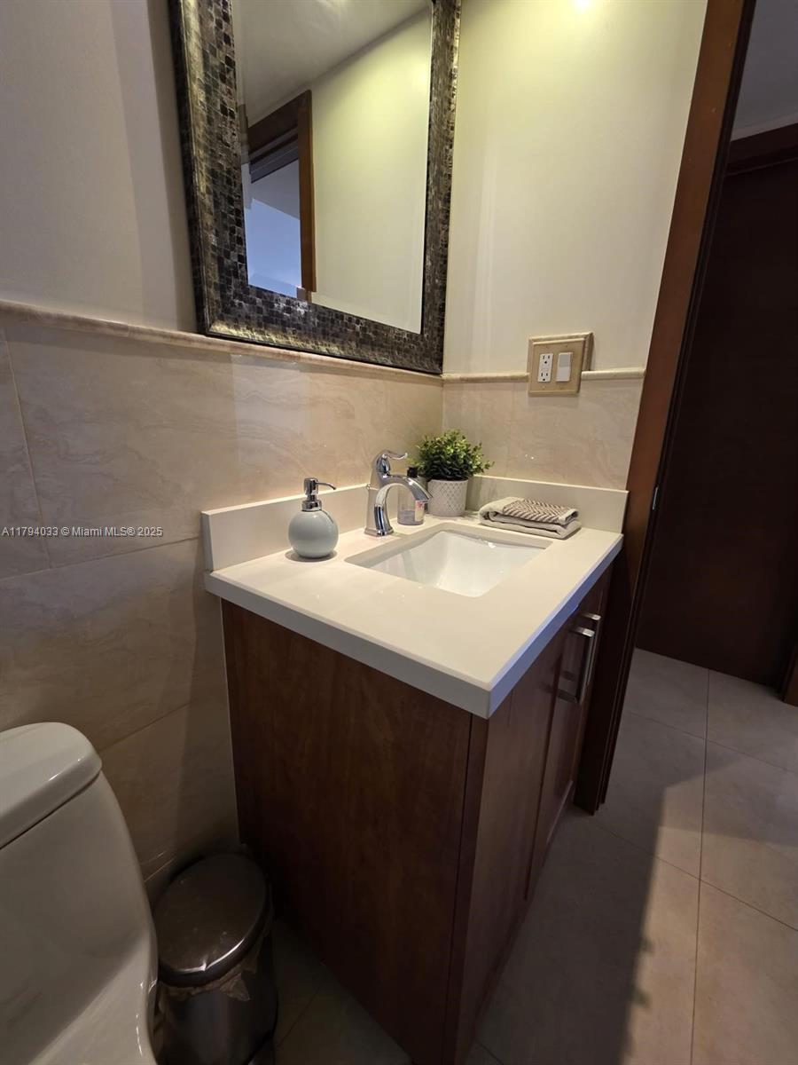 9225 Collins Avenue, Unit 1409 Surfside, FL 33154 - Photo 29 of 41 a bathroom with a sink and a toilet