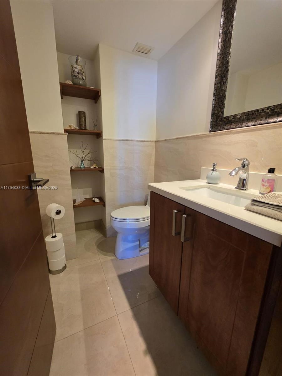 9225 Collins Avenue, Unit 1409 Surfside, FL 33154 - Photo 30 of 41 a bathroom with a sink and a toilet