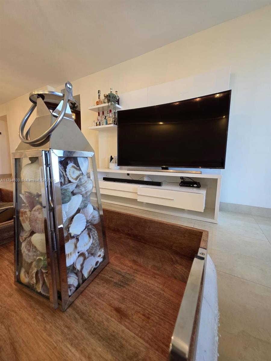 9225 Collins Avenue, Unit 1409 Surfside, FL 33154 - Photo 3 of 41 a living room with furniture and a flat screen tv