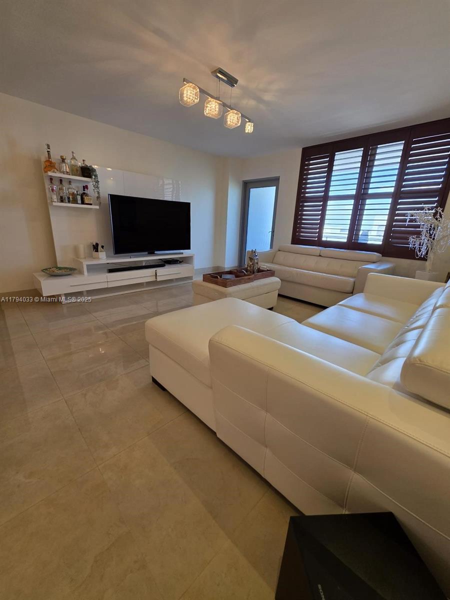 9225 Collins Avenue, Unit 1409 Surfside, FL 33154 - Photo 4 of 41 a bedroom with furniture and a flat screen tv