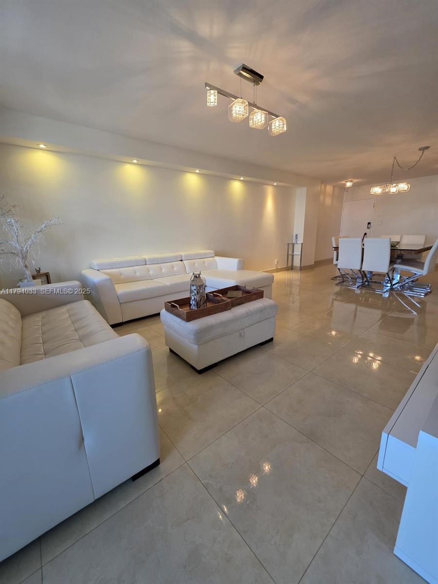 9225 Collins Avenue, Unit 1409 Surfside, FL 33154 - Photo 7 of 41 a living room with couches and kitchen view