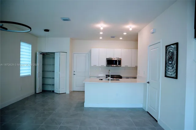 a kitchen with stainless steel appliances a refrigerator and a stove top oven