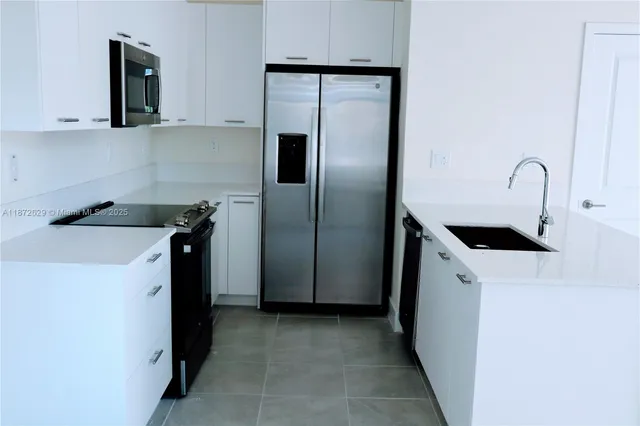 a kitchen with a refrigerator and a sink