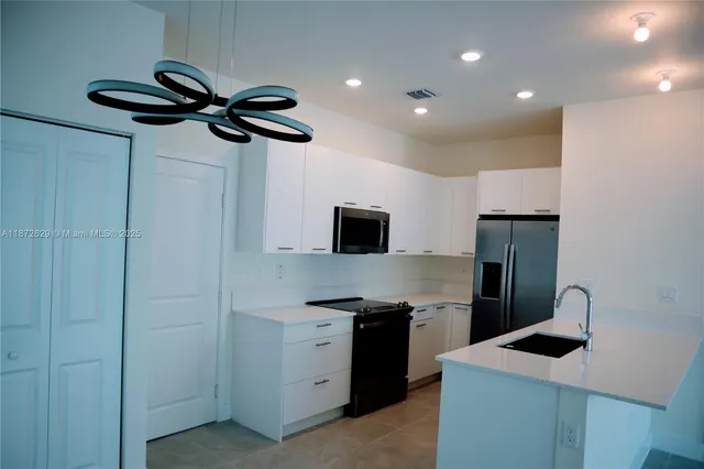 a kitchen that has a microwave a sink and a stove