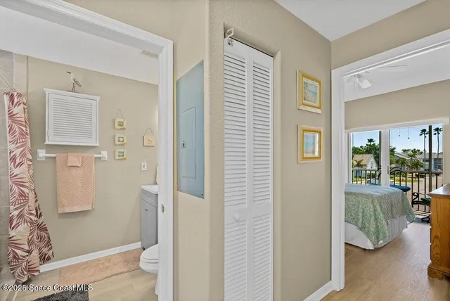 a view of a bedroom with wooden floor and windows