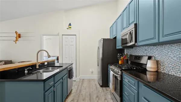a kitchen with cabinets and wooden floor
