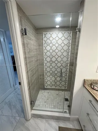 a bathroom with a shower sink and mirror