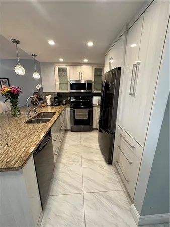 a kitchen with a sink a counter top space and appliances