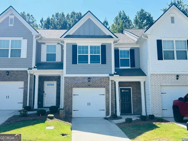 a front view of a house with yard and garage