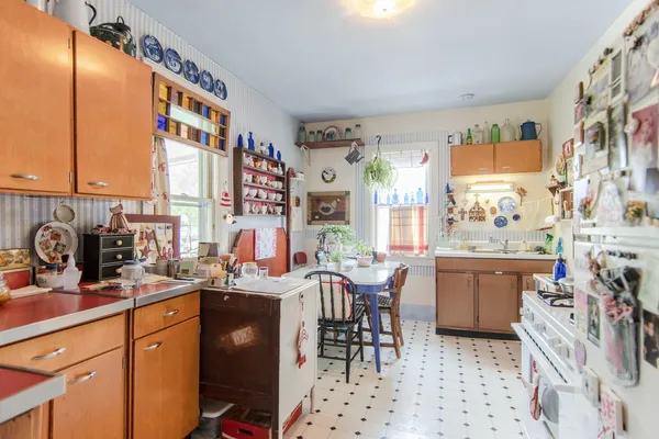 a very nice looking open dining room with kitchen island granite countertop a sink and a large window