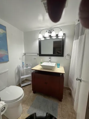 a bathroom with a sink vanity mirror and toilet