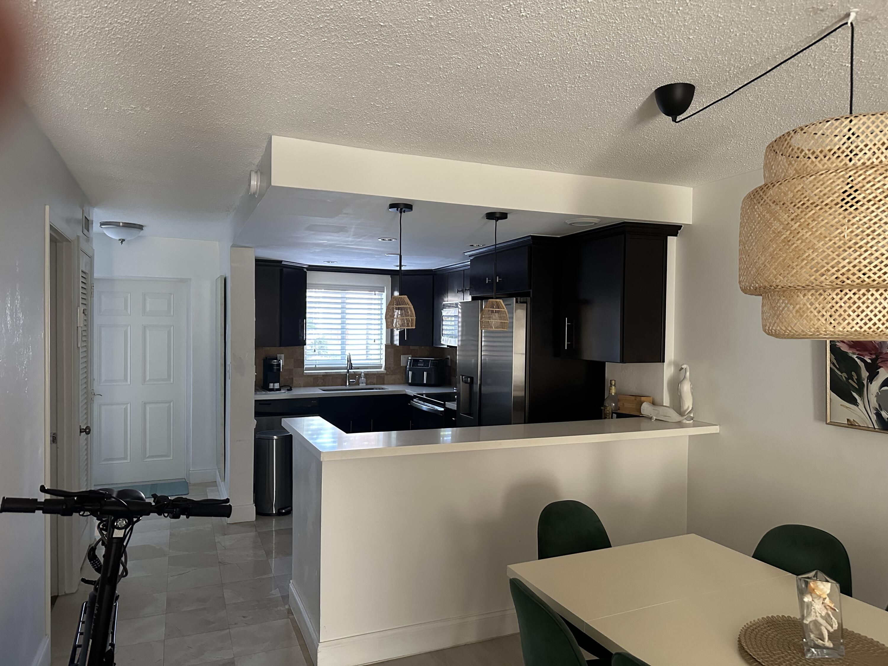 1169 Hillsboro Mile, Unit 109 Hillsboro Beach, FL 33062 - Photo 2 of 18 a kitchen with kitchen island a sink stainless steel appliances and cabinets