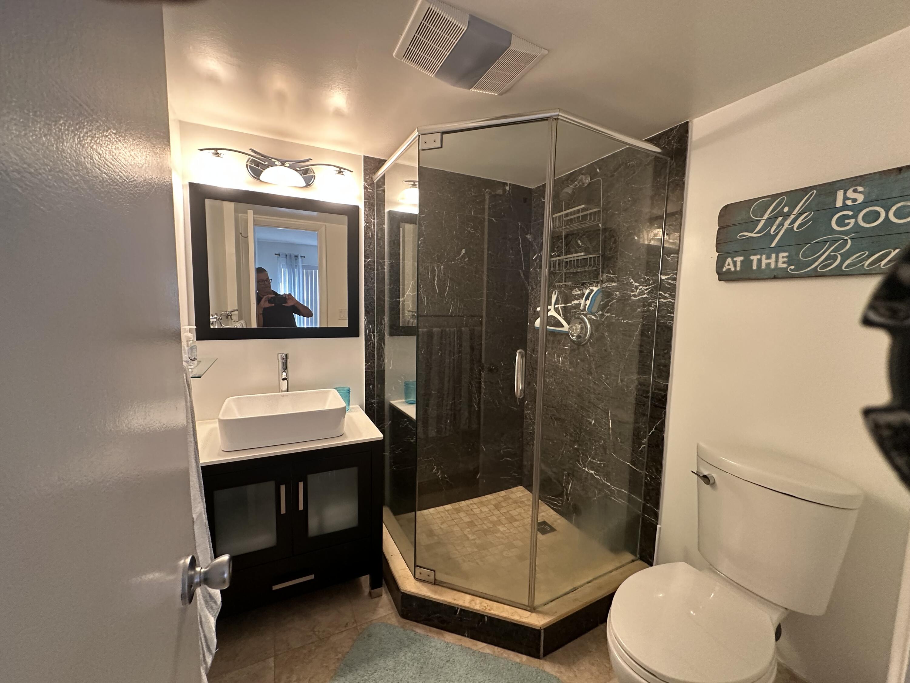 1169 Hillsboro Mile, Unit 109 Hillsboro Beach, FL 33062 - Photo 7 of 18 a bathroom with a sink a toilet a mirror and shower