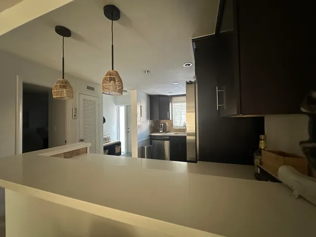 a kitchen with stainless steel appliances kitchen island granite countertop a refrigerator a sink dishwasher with a dining table and chairs