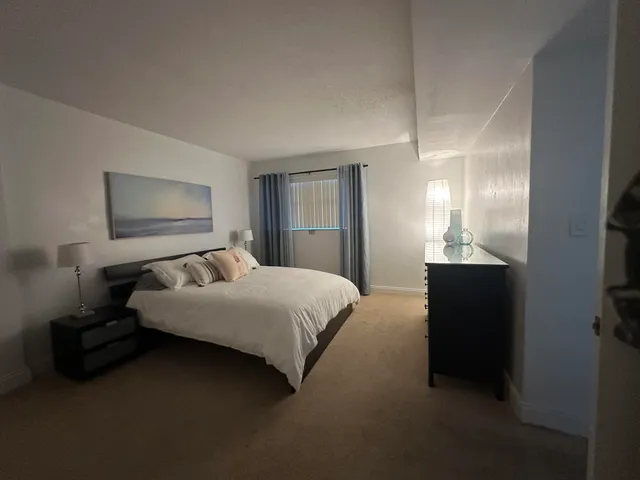 a bedroom with a bed and a painting on the wall