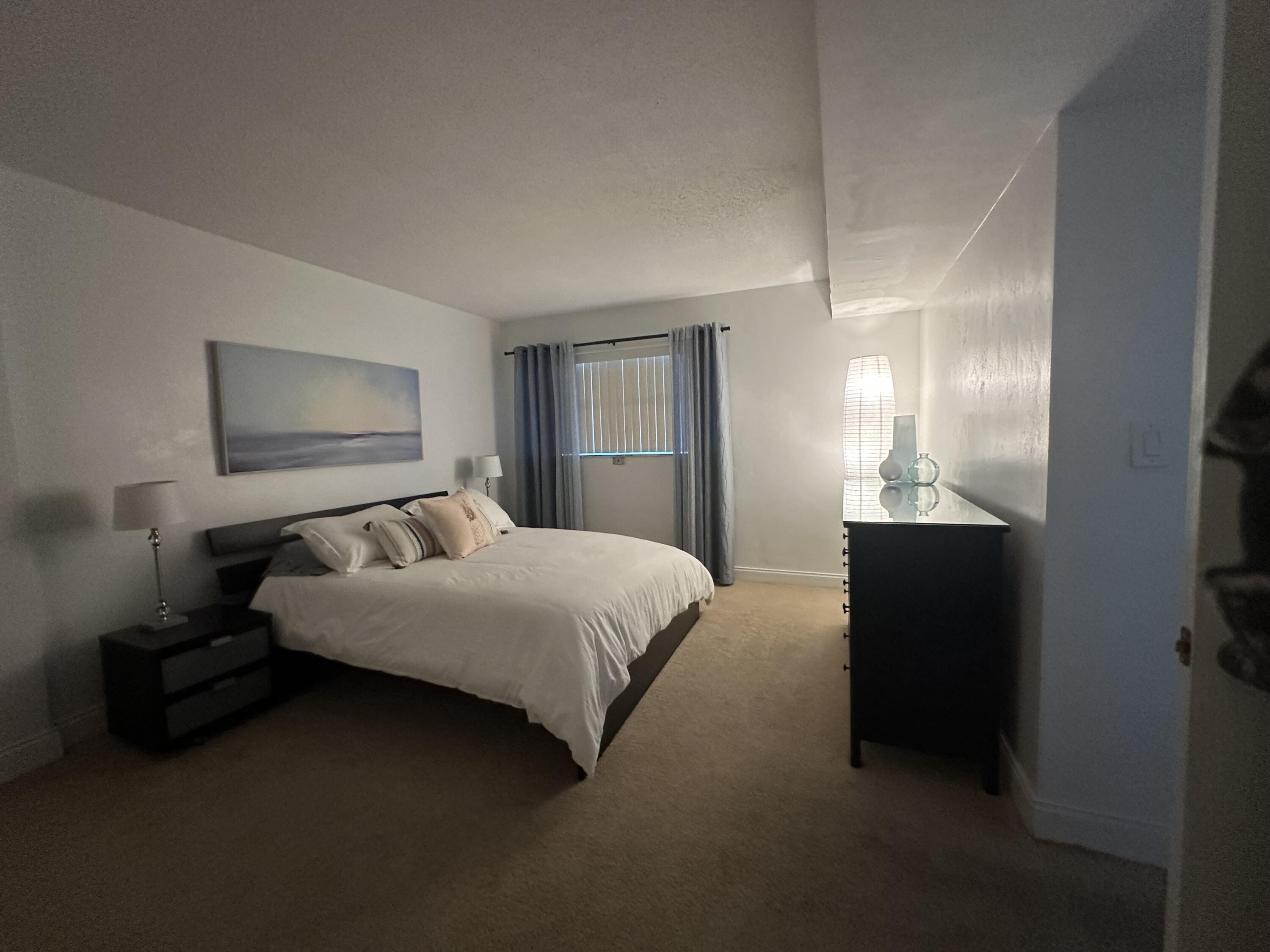 1169 Hillsboro Mile, Unit 109 Hillsboro Beach, FL 33062 - Photo 10 of 18 a bedroom with a bed and a painting on the wall