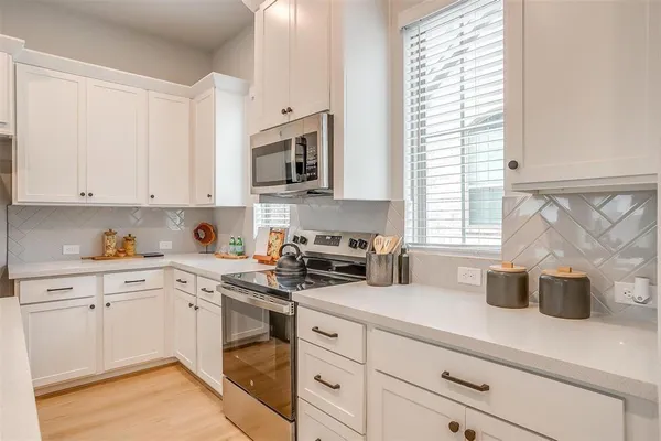 a kitchen with cabinets appliances a sink and a window