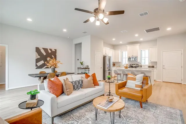 a living room with furniture kitchen view and a chandelier